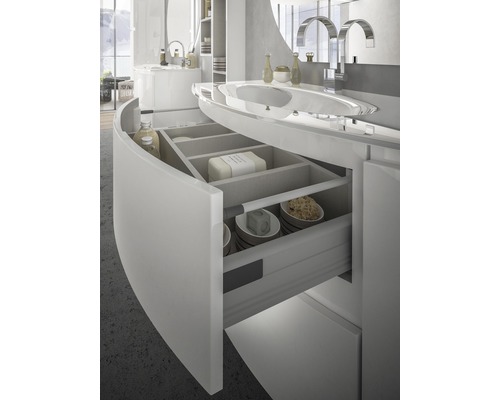 Ljus badrumsinredning med öppen låda under ett handfat