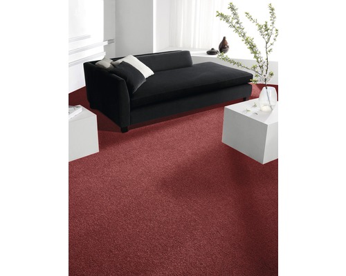Interiör med röd matta, svart soffa och vita sidobord.