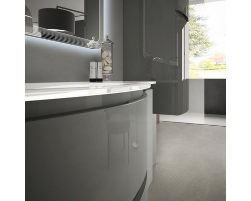 Badrum med handfat, spegel och dusch i modern design.