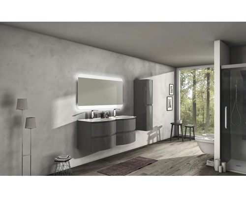 Modernt badrum med tvättställ, spegel med belysning, högskåp och fönster med utsikt över skogen