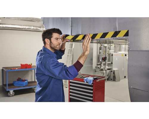 Man fäster varningsmärkning på ett ventilationsschakt.