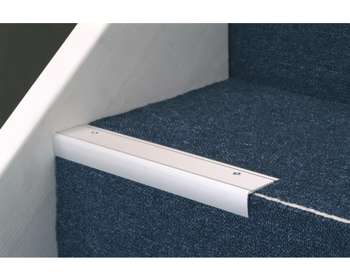 Trappnoslist i aluminium på en trappa täckt med matta