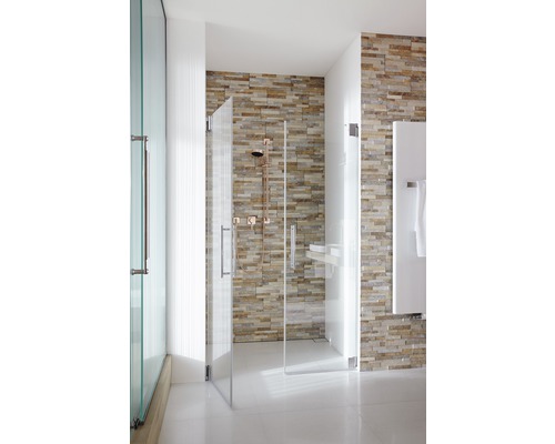 Duschkabin med glasväggar och stenvägg