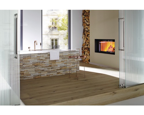 Badrum med badkar, öppen spis, vedstapel och trägolv