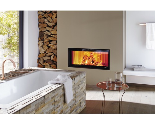 Badrum med badkar, öppen spis och vedstapel