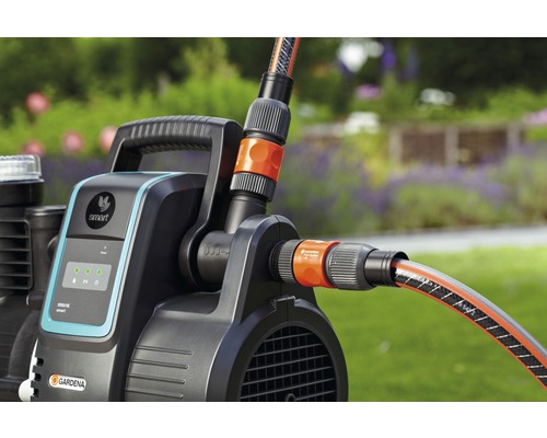 Gardena hydroforpump med ansluten vattenslang i trädgården