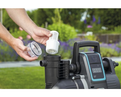 En person sätter in ett filter i en trädgårdspump.
