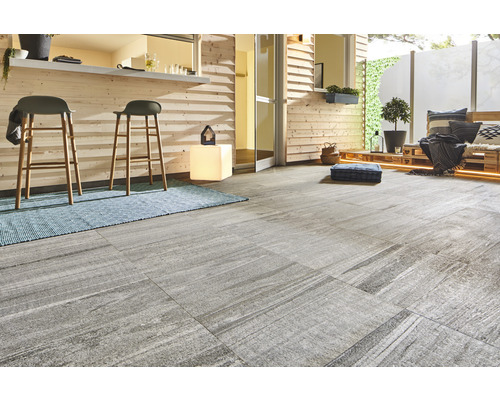 Terrass med grå golvplattor, barstolar och träpanel