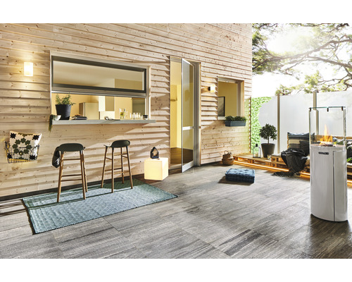 Terrass med träpanel, barstolar, matta och uteplatsvärmare