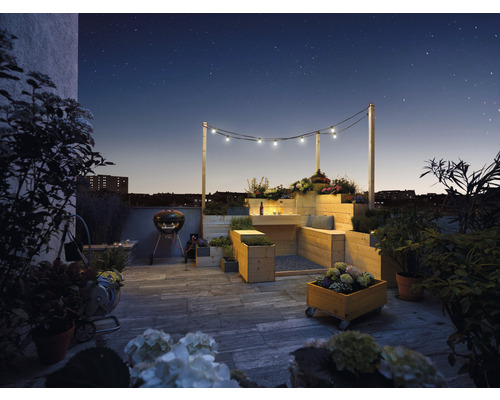 Takterrass med trämöbler, grill och belysning under stjärnhimlen