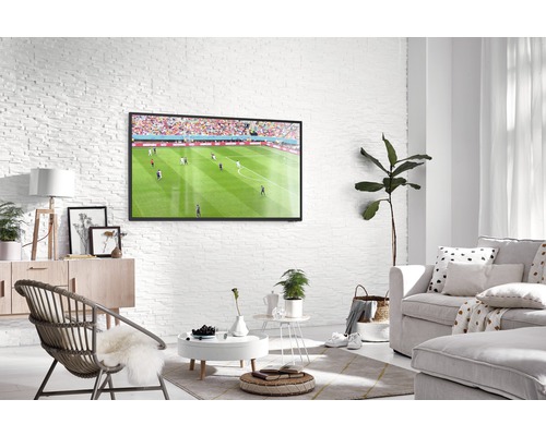 Ljust vardagsrum med TV, soffa och fåtölj