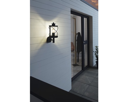 Belyst yttervägglampa i lyktstil på en husvägg