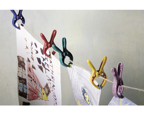 Färgglada klädnypor håller barns teckningar på en torklina