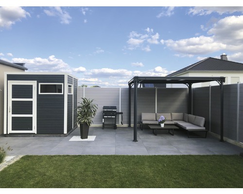 Trädgårdsvy med redskapsbod, grill och täckt sittgrupp