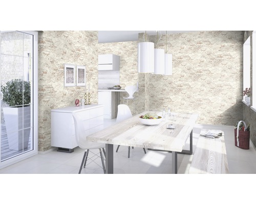 Ljust rum med matbord, stolar och väggbeklädnad i stenlook.