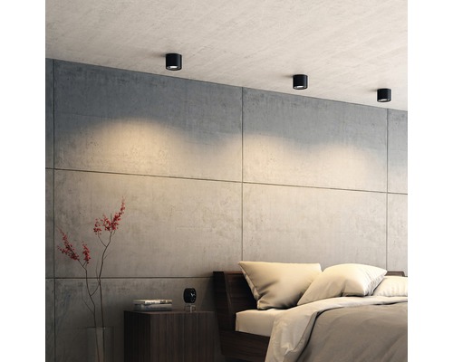 Sovrum med taklampor, säng och sängbord