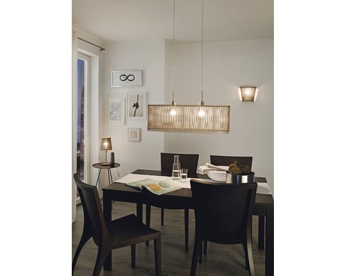 Matbord med pendellampa och vägglampa för en ljus och inbjudande atmosfär.