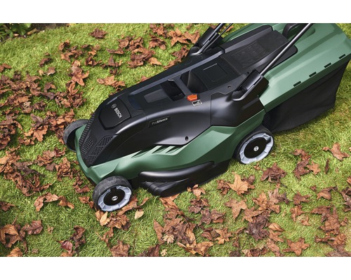 Bosch gräsklippare på gräsmatta med höstlöv