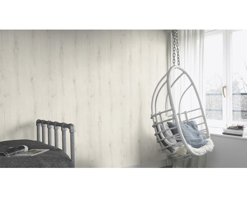 Ljust rum med trävägg, hängstol och säng