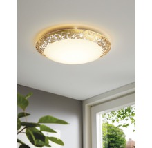 Guldfärgad taklampa med rund lampskärm i rummet
