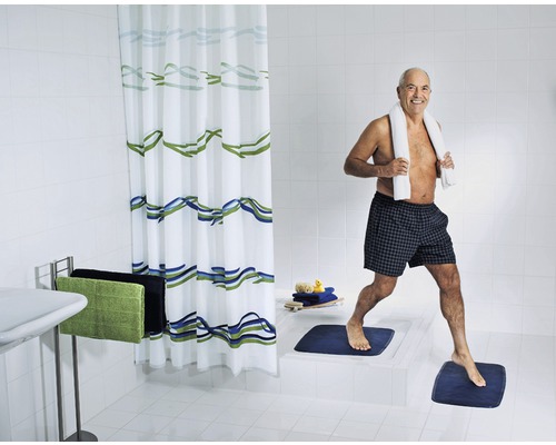 Ljust badrum med duschdraperi, badrumsmattor och handdukar