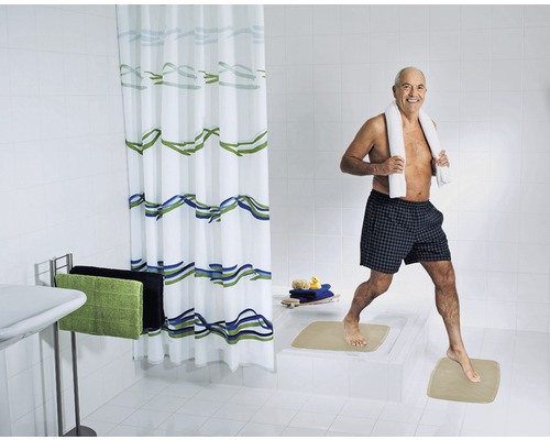 Ljust badrum med duschdraperi, handdukar och badrumsmattor