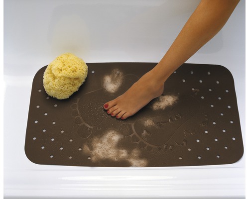 Brun badrumsmatta med fotavtrycksmönster, fötter och badsvamp i badkar