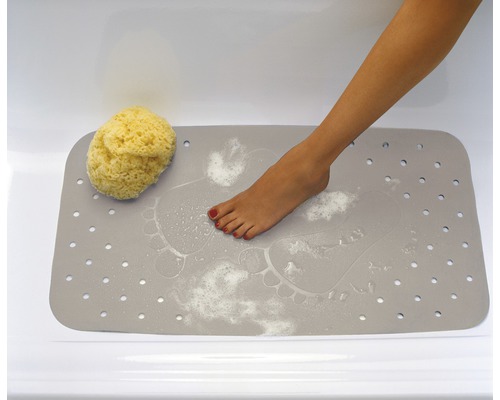 Grå badrumsmatta med fotavtryck, badsvamp och fot i badkaret