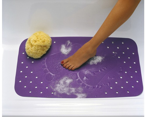 Lila badrumsmatta med fotavtrycksmönster, badsvamp och fot i badkar.