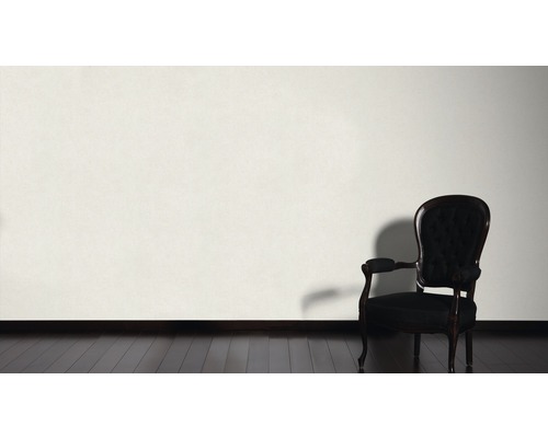 Dekorativ scen med en fåtölj framför en vägg på ett trägolv