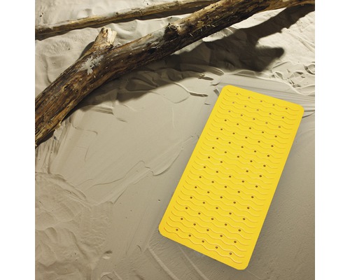 Gul badrumsmatta med sugproppar på beige bakgrund och trädstam