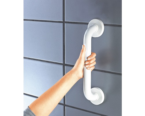 Hand som håller ett vitt stödhandtag på väggen i badrummet