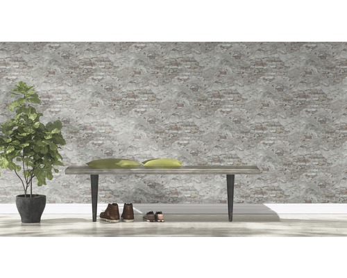 Dekorativ interiör med bänk, kuddar, krukväxt och skor mot en vägg med tegelstensmönster