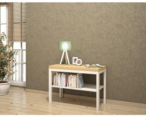 Dekorativt vardagsrum med konsolbord, bordslampa och böcker framför en mönstrad vägg