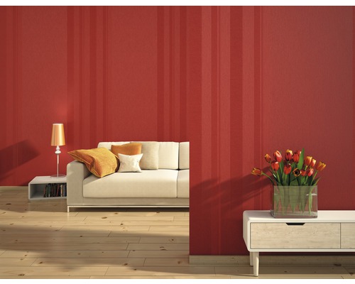 Vardagsrum med randig tapet, soffa, bordslampa och blomvas