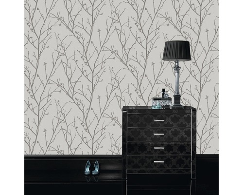 Tapet med trädgrensmönster i rum med byrå och lampa