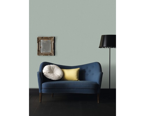 Miljöbild med blå soffa, kuddar, golvlampa och spegel