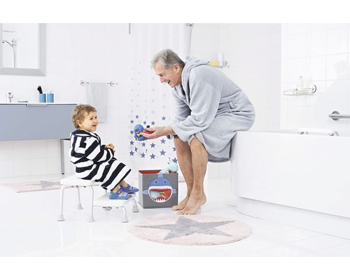 Badrumsscen med barn på pall och vuxen på badkar