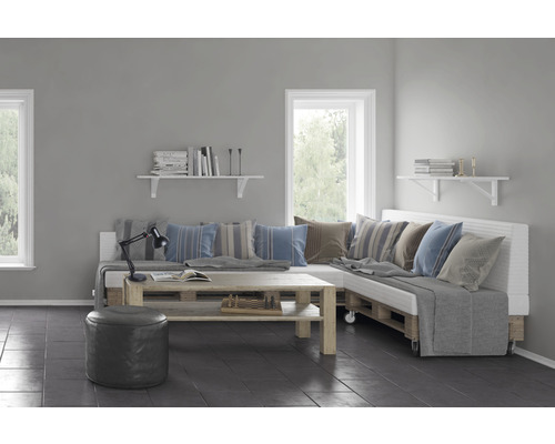 Vardagsrum med pallsoffa, träbord, hyllor och fönster