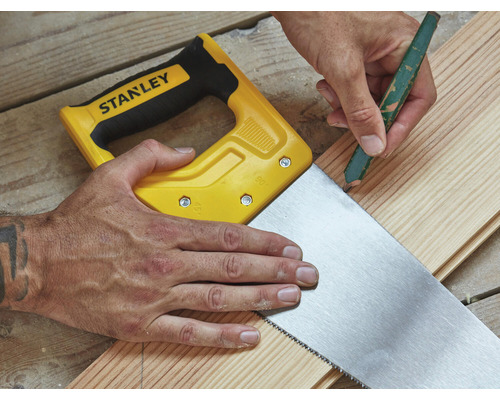 Hantverkare markerar träplanka med penna och såg