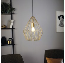 Gyllene hänglampa med geometrisk design hänger i rummet.