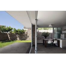 Ljus, rymlig inredning med matplats, pentry och tillgång till trädgården genom en bred skjutdörr.