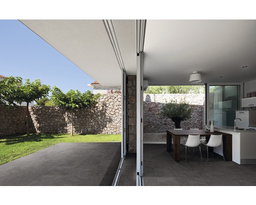 Ljus, rymlig inredning med matplats, pentry och tillgång till trädgården genom en bred skjutdörr.