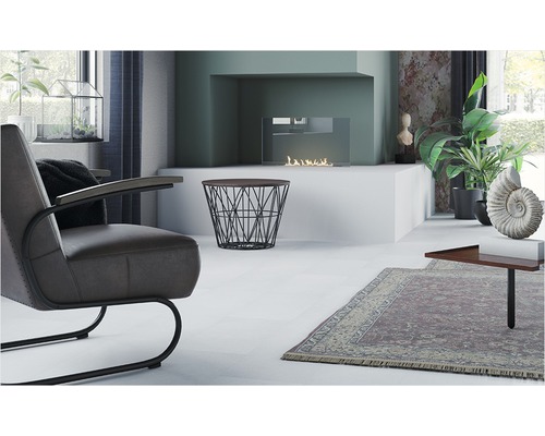 Ljust vardagsrum med fåtölj, öppen spis och dekorativa element