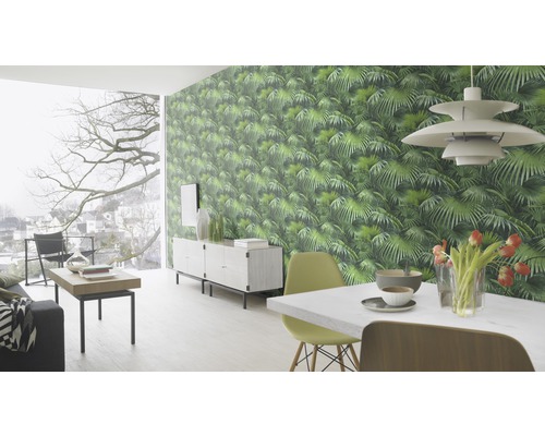 Vardagsrum med grön mönstrad djungeltapet, matbord och skänk