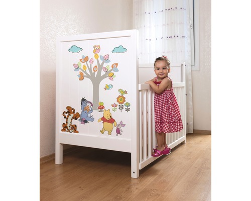 Vit barnsäng med Nalle Puh-motiv i ett barnrum.