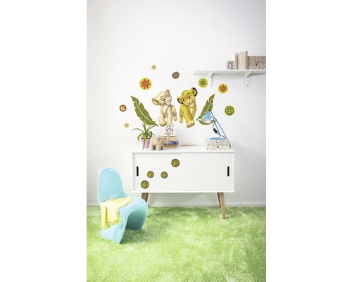 Rumsdekoration med väggdekaler av två lejonfigurer, cirklar och löv ovanför ett skåp med tassavtrycksdekaler.