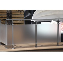 Trädgårdsscen med insynsskydd av glas och metall på en träterrass