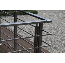 Närbild av ett rostfritt stålräcke på en träterrass