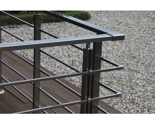 Närbild av ett rostfritt stålräcke på en träterrass